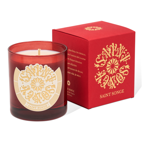 Bougie parfumée Saint Songe de 280 grammes dans son pot en verre rouge et son étiquette ivoire et or, à coté de son étui rouge et or